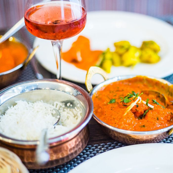 Indian Meal (Rice, Potato in Curry, Chicken Masala) and Wine in Luxury Indian Restaurant