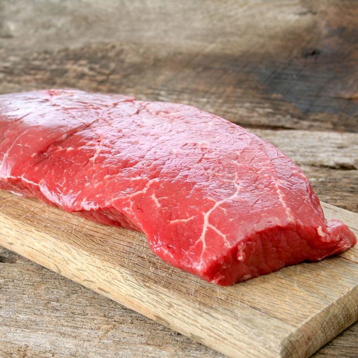 london broil steak on wood cutting board