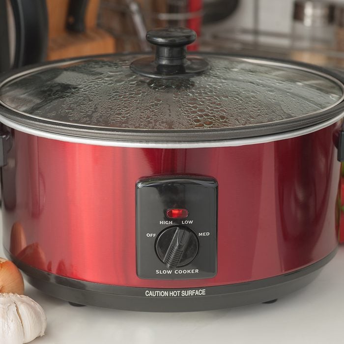 Close up of a slow cooker working on kitchen shelf; Shutterstock ID 310888622