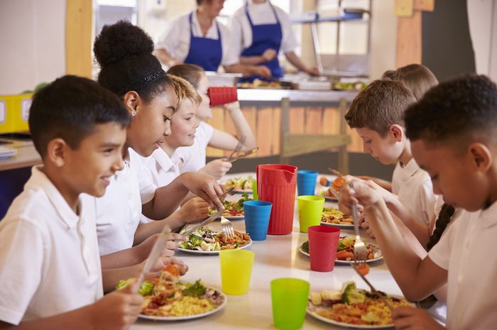 Primary school kids eating at a table