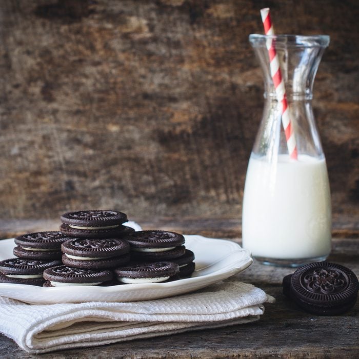 Sweet chocolate cookies and bottle of milk on wooden background