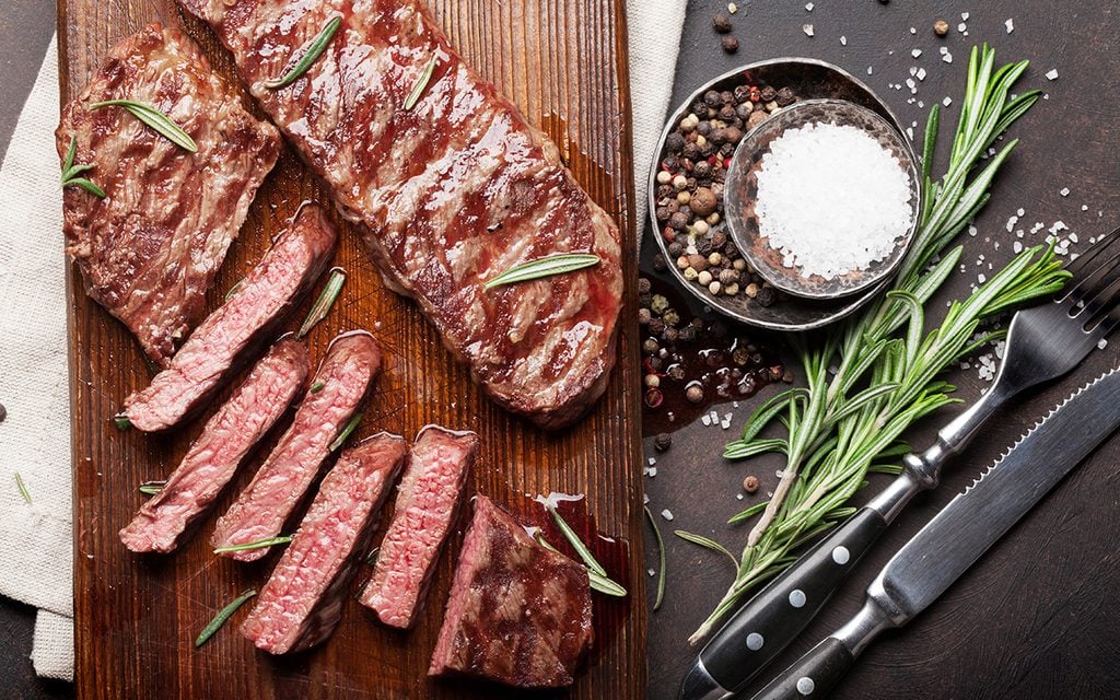 Top blade or denver grilled steak over cutting board.