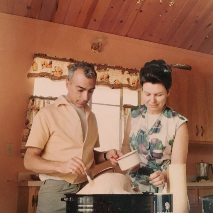 a man and woman prepare thanksgiving turkey in their cabin