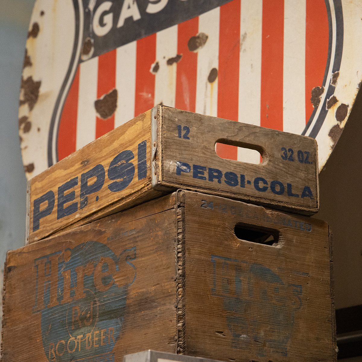Vintage Wooden Pepsi-Cola and Hires Root Beer crates sit atop a freezer in a local grocery store in a mountain town