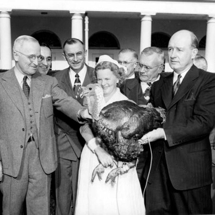 President Truman pardons turkey being held by woman and a group of men 1940s