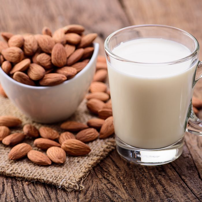 Almond milk in glass with almonds