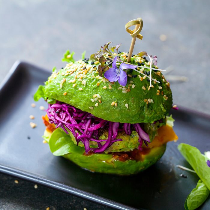 Avocado sandwich with green vegan burger, roast yellow pepper and pickled red cabbage