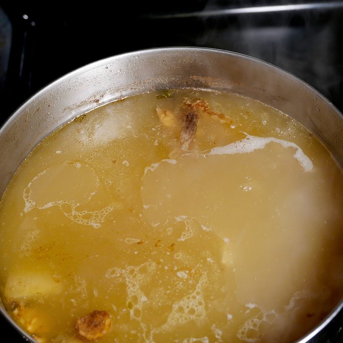 Pot of simmering pork stock on the stove with a skim of fat on the surface, and steam rising from it.; Shutterstock ID 758373580; Job (TFH, TOH, RD, BNB, CWM, CM): TOH