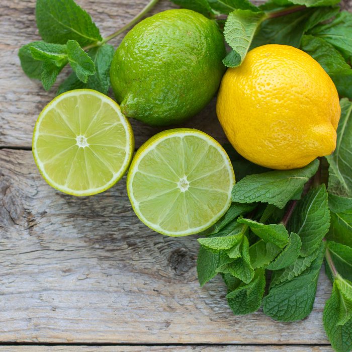 Juicy ripe citrus on an old wooden table - lime, lemon and mint