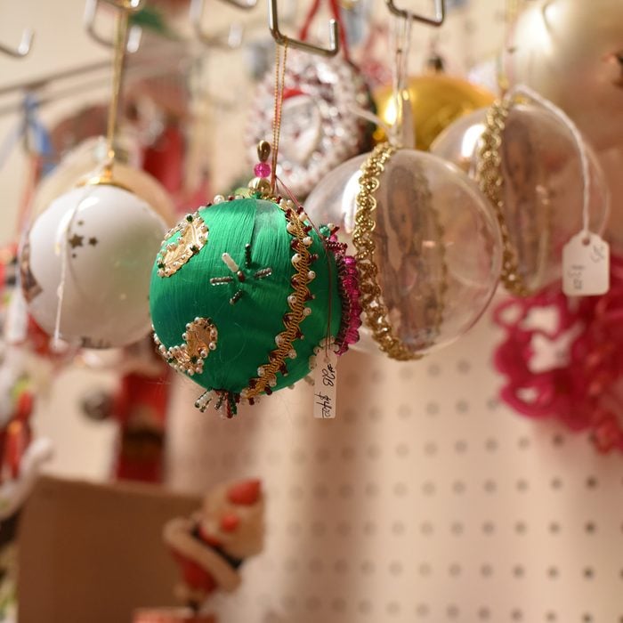 Colorful antique vintage Christmas ornaments displayed for sale on a pegboard in a thrift store. 
