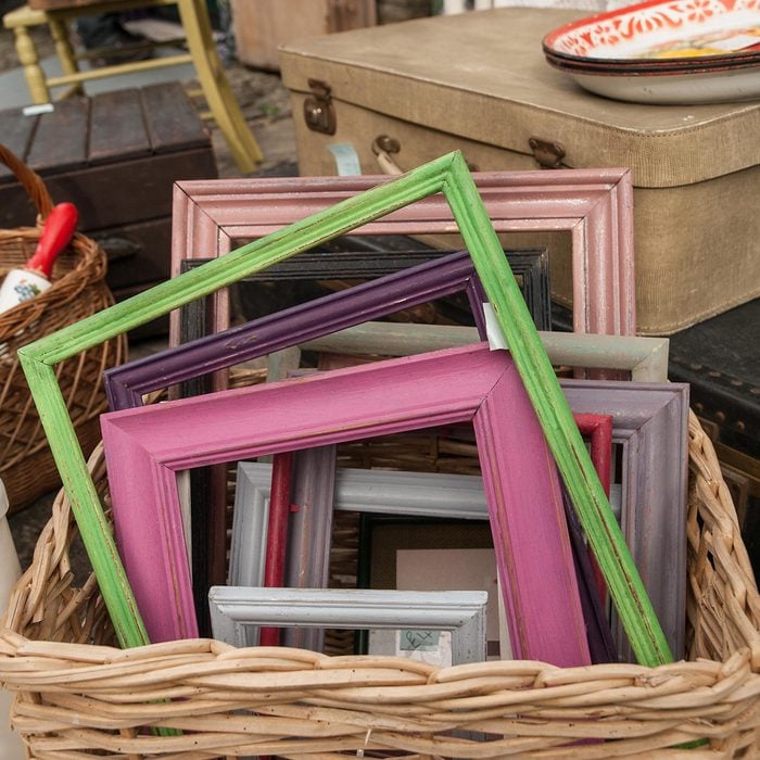 Differed coloured painted wood frames in a basket for sale at a vendor in Hay-on-Wye, Wales, United Kingdom, Europe.