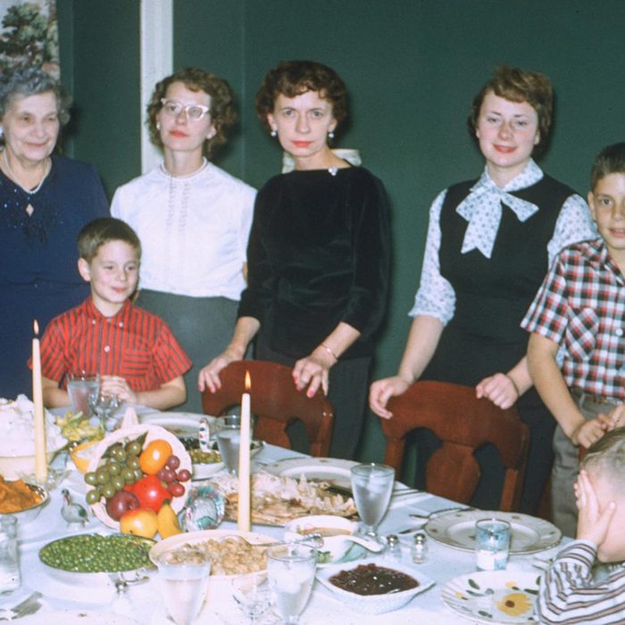 family poses around the thanksgiving table