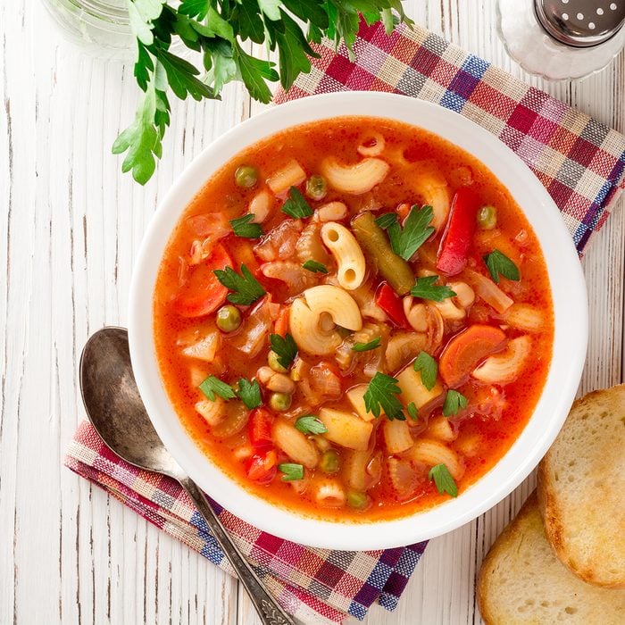 Italian minestrone soup on white wooden background.