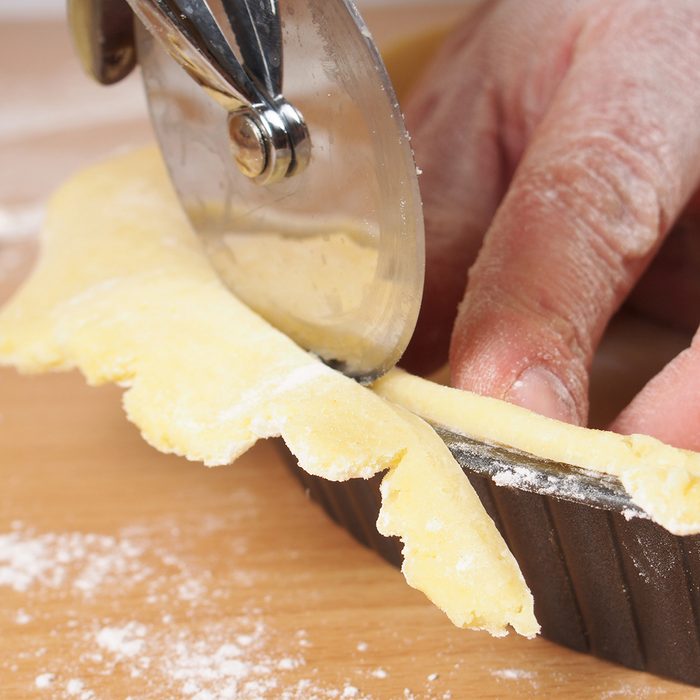 Trim off the excess of pastry. Making Apple Pie Tart Series.; Shutterstock ID 255711346; Job (TFH, TOH, RD, BNB, CWM, CM): TOH