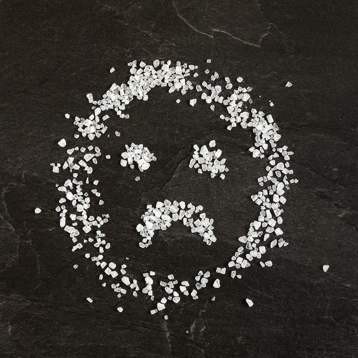 Sad face emoticon made from salt crystals