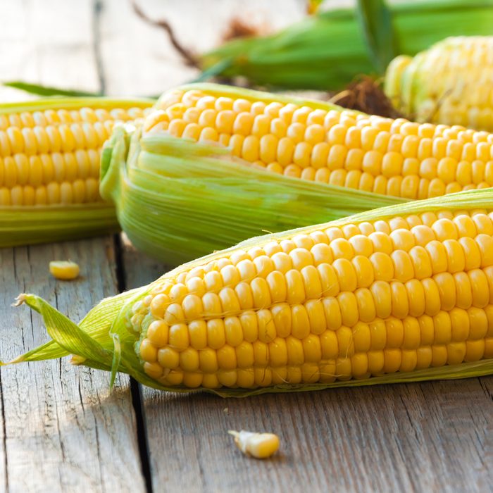 High-fiber foods: Fresh corn on cobs on wooden table, closeup, top view; Shutterstock ID 473507224; Job (TFH, TOH, RD, BNB, CWM, CM): Taste of Home