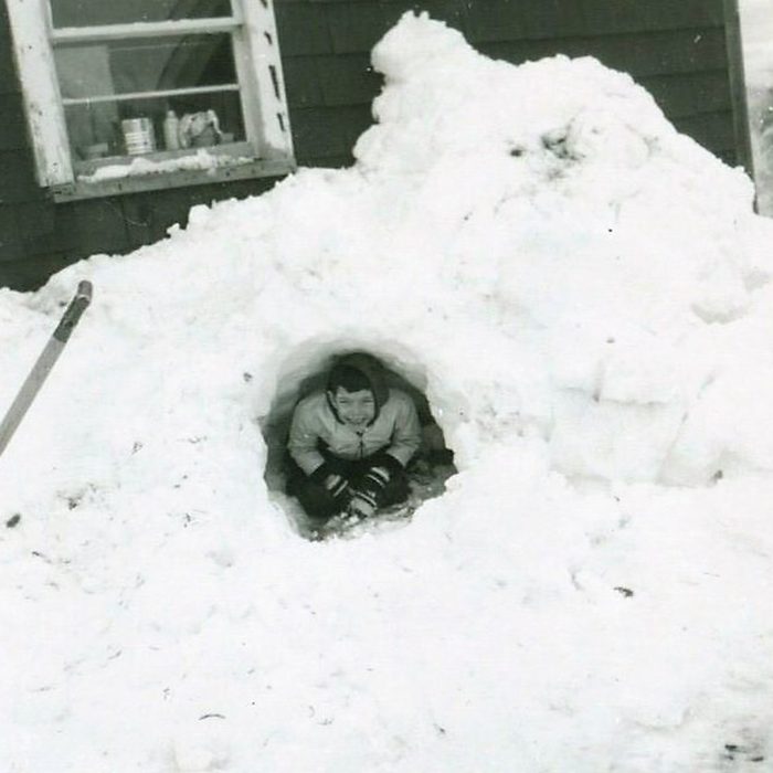 Kid poking out from a tunnel in the snow