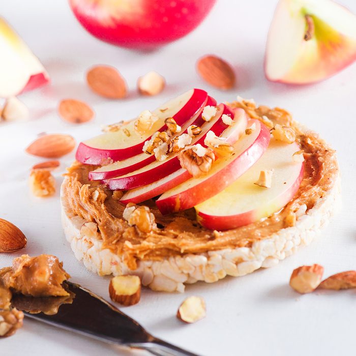 Apple crisp bread toast with apple slices, peanut butter, almonds and walnuts.