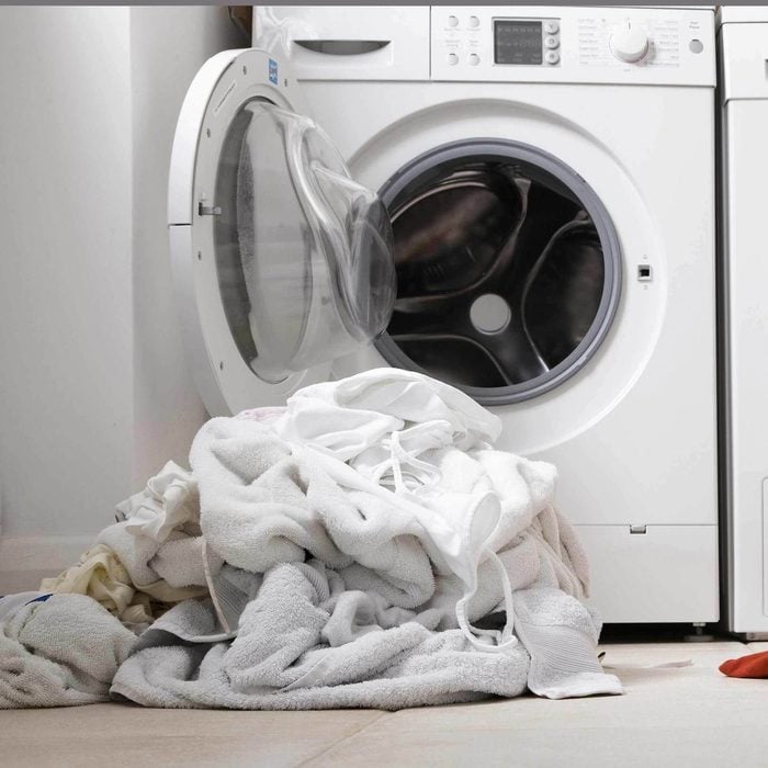 Laundry room washing machine pile of white clothes