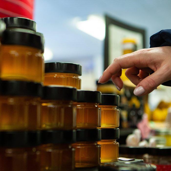 Hand reaching for a jar of honey