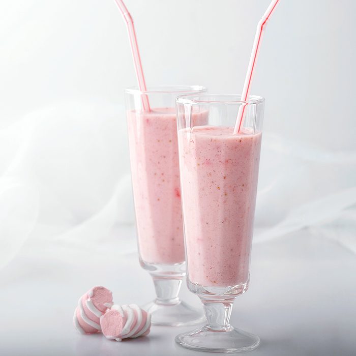 Pink cocktail and marshmallows isolated on white gray background.