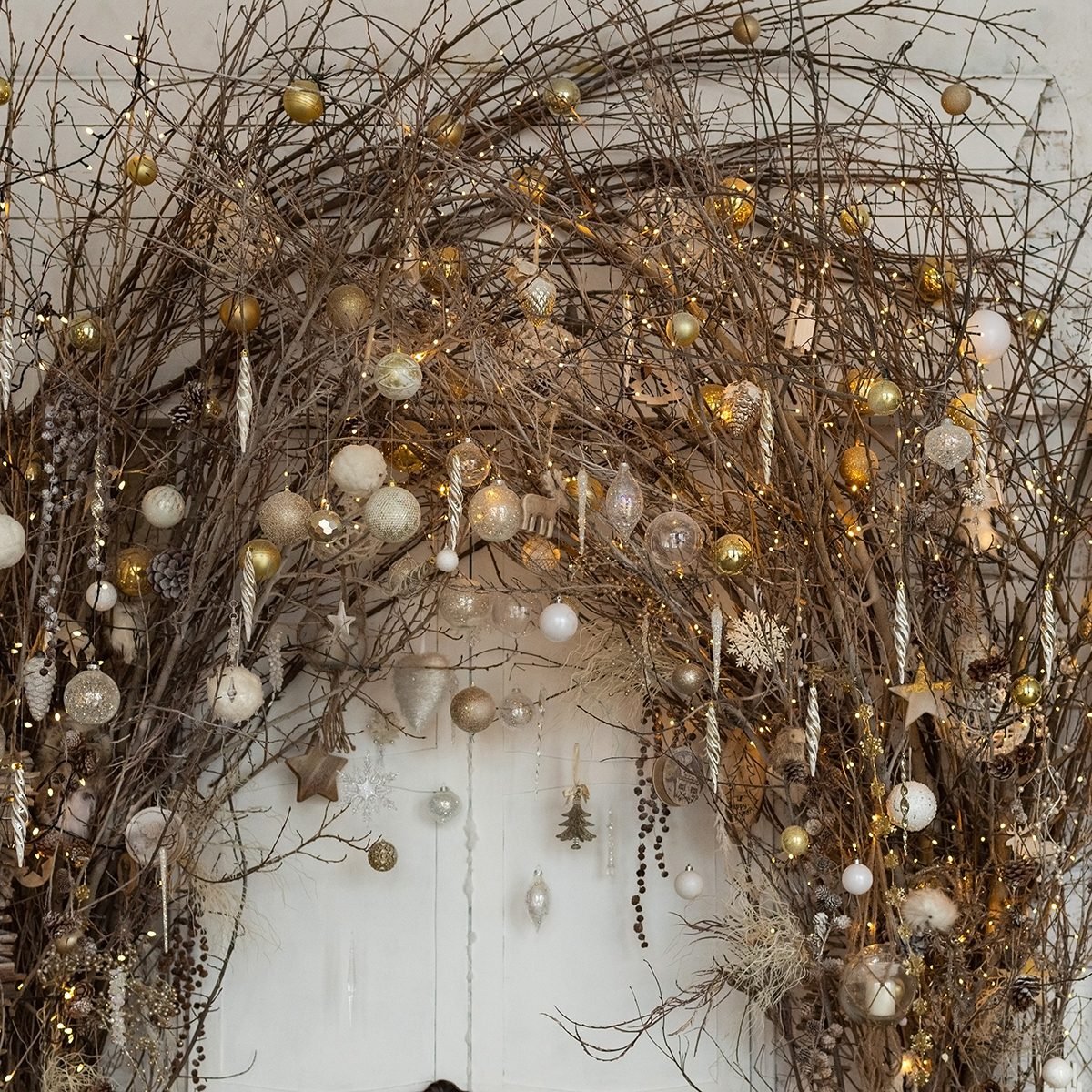Christmas decorations with natural details: branches with garland lights and christmas balls. Eco decor in interior concept. Creative christmas tree.