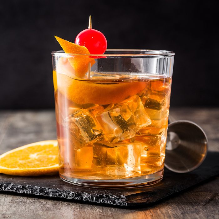 Old fashioned cocktail with orange and cherry on wooden table. Copyspace; Shutterstock ID 1338703802; Job (TFH, TOH, RD, BNB, CWM, CM): TOH