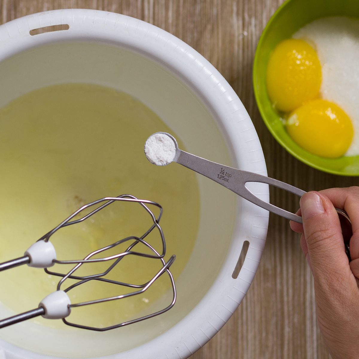 Hand of woman holding the measure spoon with cream of tartar to put it into egg whites before beating; Shutterstock ID 1503064133; Job (TFH, TOH, RD, BNB, CWM, CM): TOH