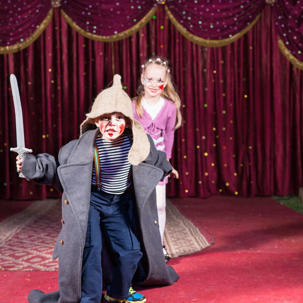 Cute talented boy playing the role of a brave Russian warrior fighting with a sward to defense his beautiful wife, in a theatrical performance at school; Shutterstock ID 275612612