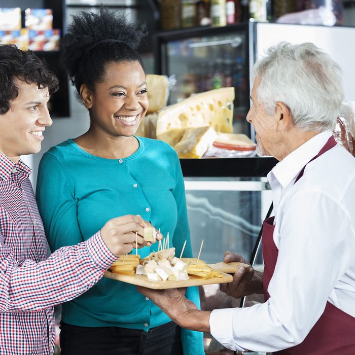 Salesman Offering Cheese Samples To Customers In Shop; Shutterstock ID 414153787; Job (TFH, TOH, RD, BNB, CWM, CM): TOH