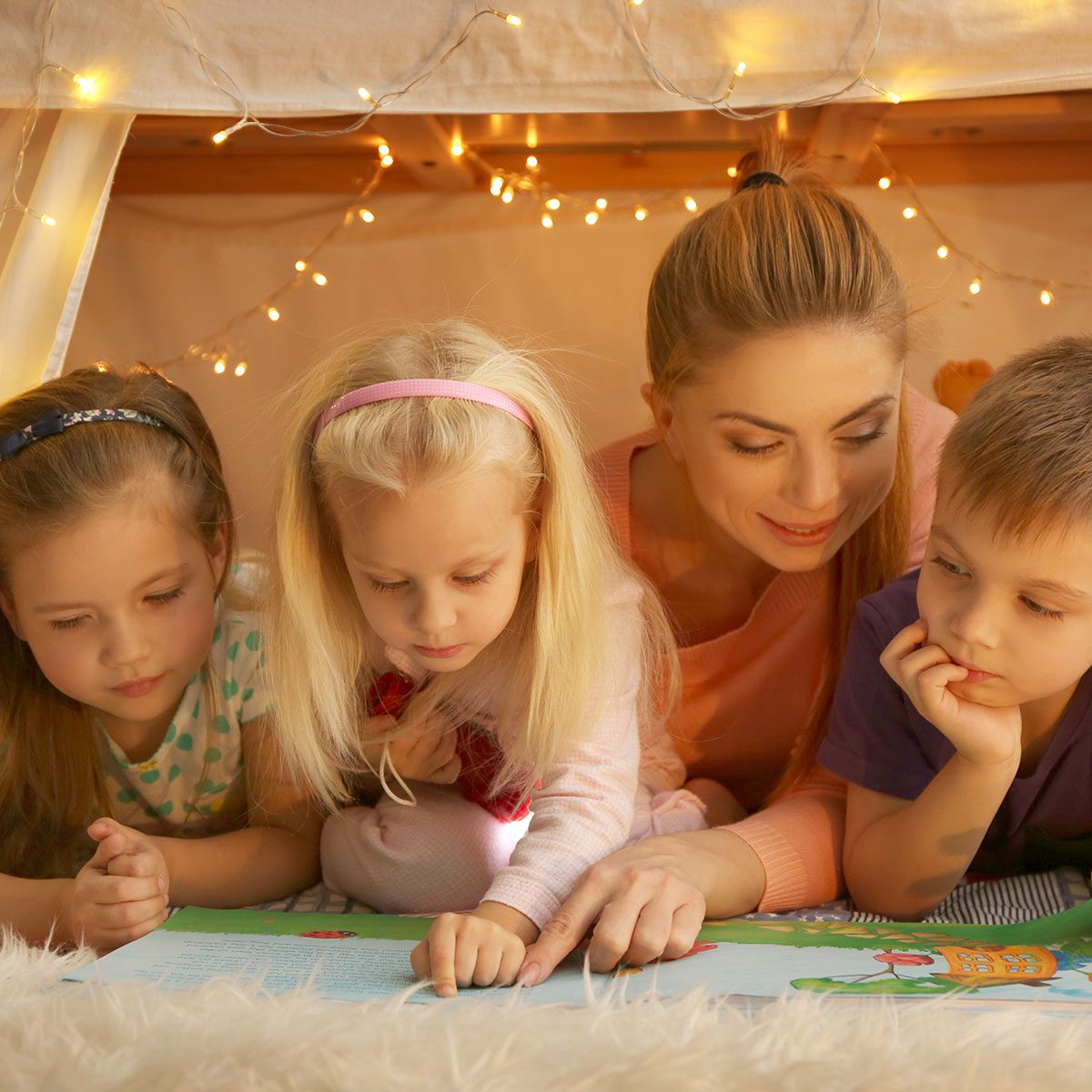 Young woman and cute children reading book in hovel at home; Shutterstock ID 598451210; Job (TFH, TOH, RD, BNB, CWM, CM): TOH