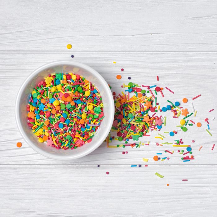 Top view of bright colorful sugar sprinkles or confetti in white bowl as baking decor