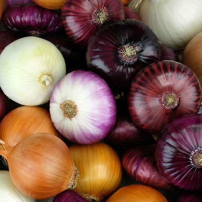 Onions of different varieties and colors for background.