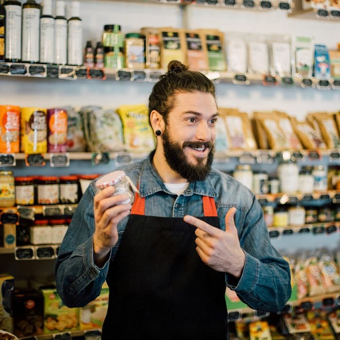 Young man showing healthy food products at the shop