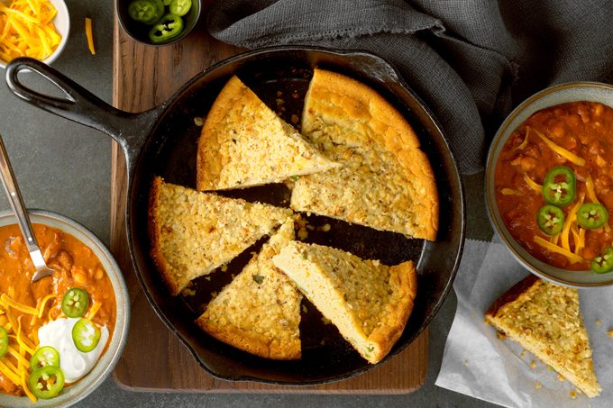 cast iron pan of corn bread between two bowls of chili