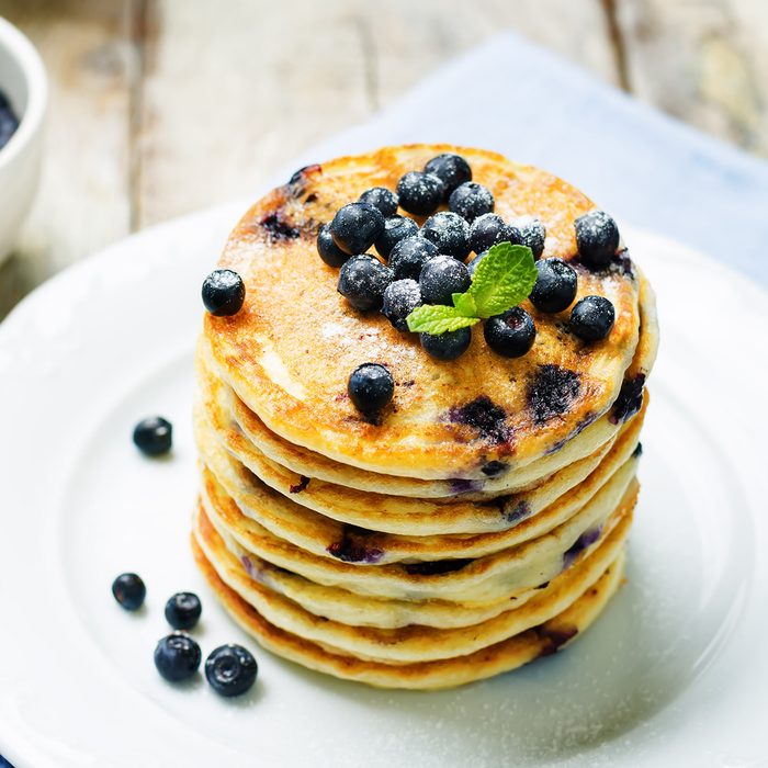 Blueberry Ricotta Pancakes with fresh blueberries and cup of coffee. toning. selective focus