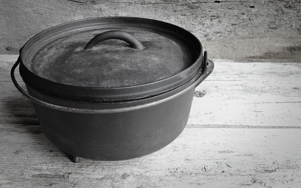 Cast Iron Dutch Oven With Old Wooden Background