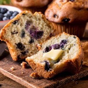 Fresh baked blueberry muffins with melted butter.