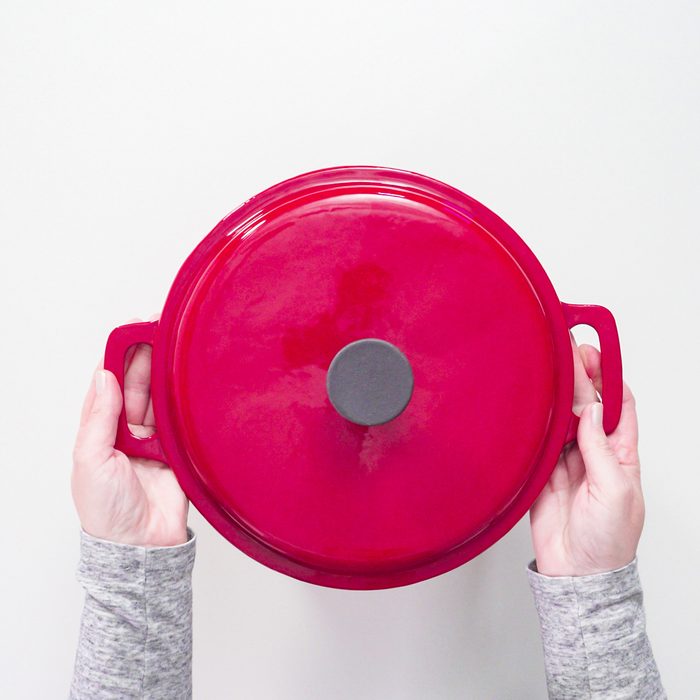 Flat lay. Red, white, and blue enameled cast iron covered dutch oven on a white background.