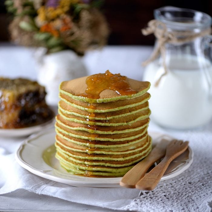 Spinach pancakes with milk and organic honey in honeycombs.