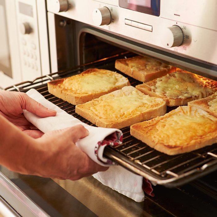 Cheese On Toast Being Grilled In Oven And Taken Out