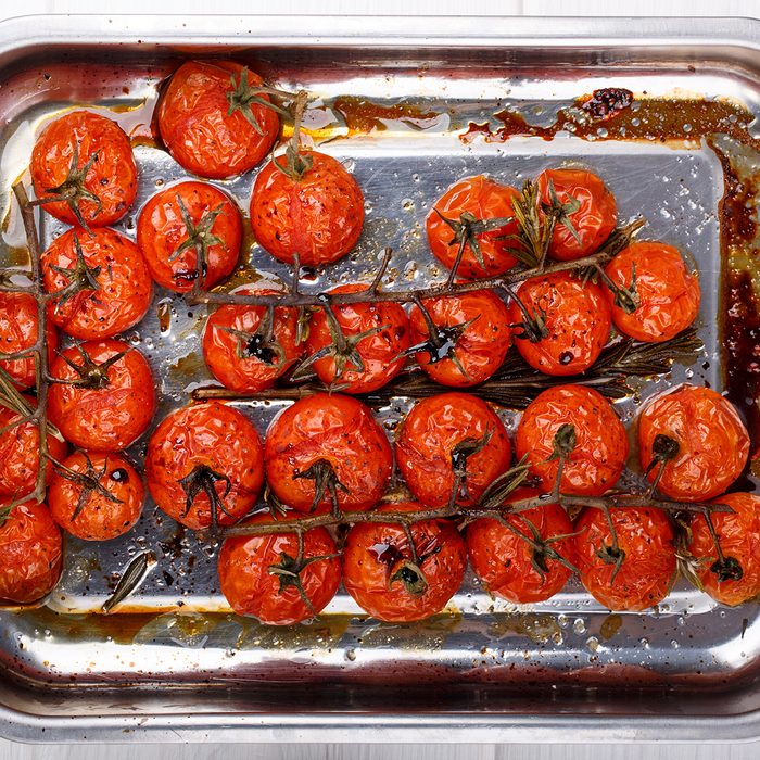 Cherry tomatoes on the vine roasted with herbs and balsamic vinegar. Top view.