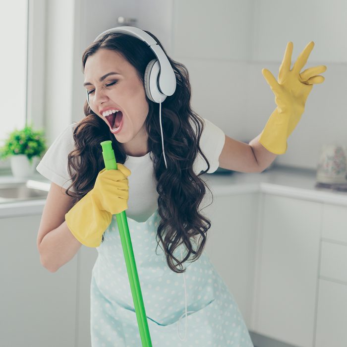 Full length body size portrait of her she nice beautiful lovely cheerful cheery funny wavy-haired house-wife using broom like mic fooling having fun in modern light white interior indoors