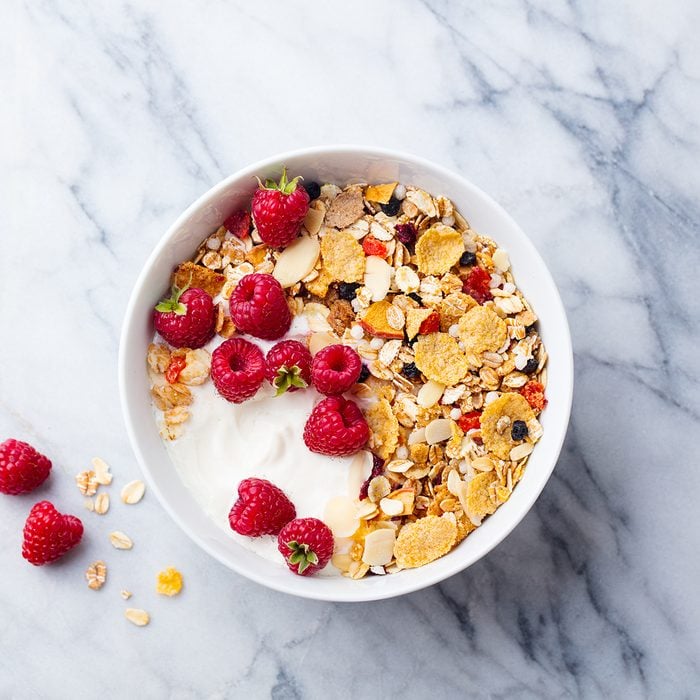 Healthy breakfast. Fresh granola, muesli with yogurt and berries on marble background. Top view