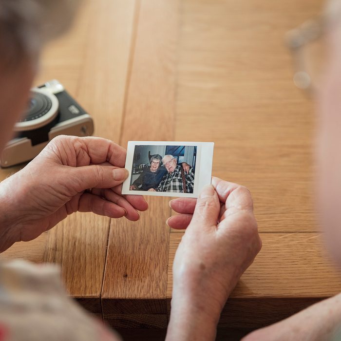 Senior couple looking at a instant film photo of themselves.