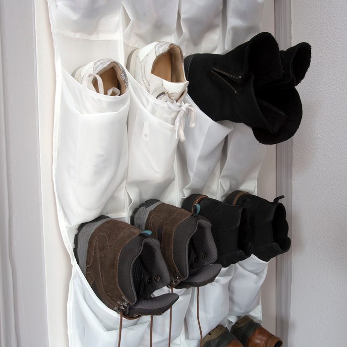 Shoe rack hanging on a wooden door, storage for shoes close-up