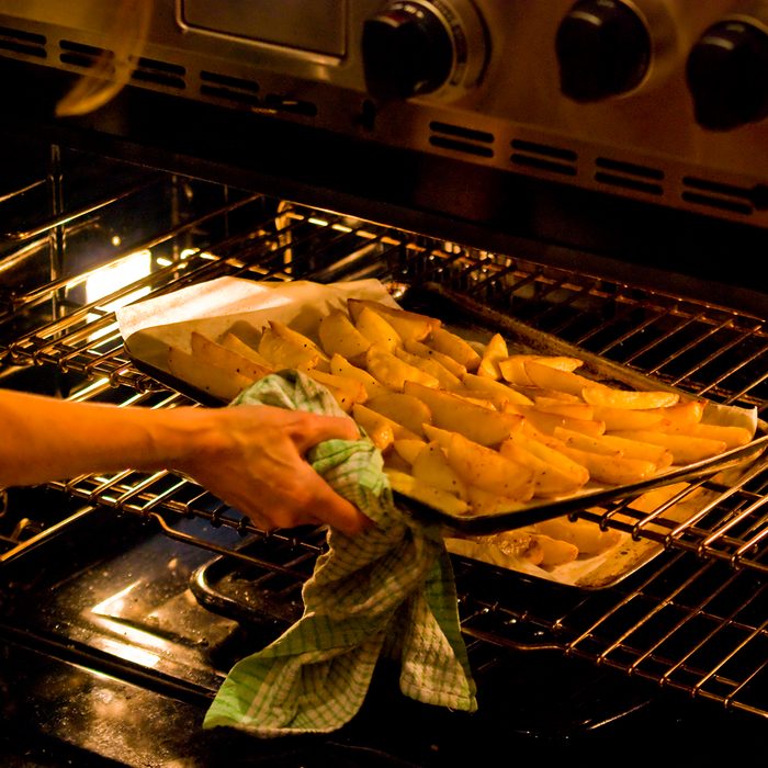 Woman lifting tray out of oven