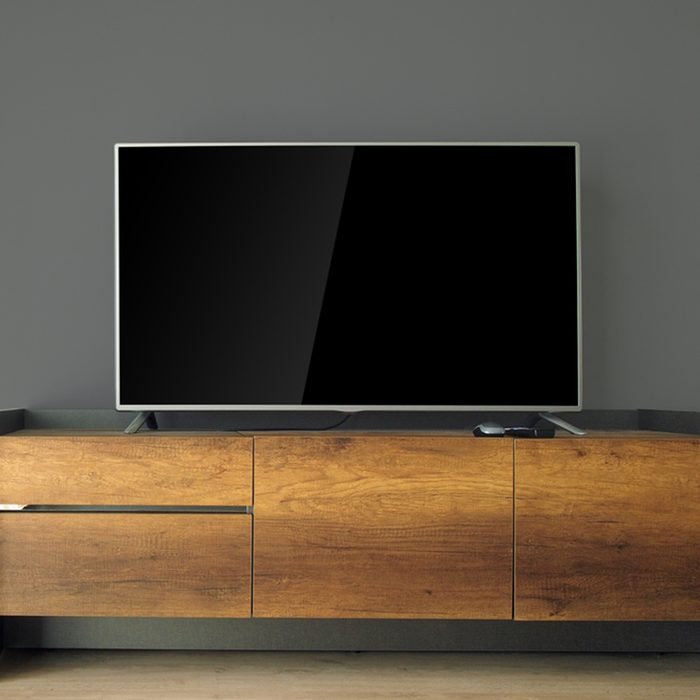 Led TV on TV stand with black wall; Shutterstock ID 381753865
