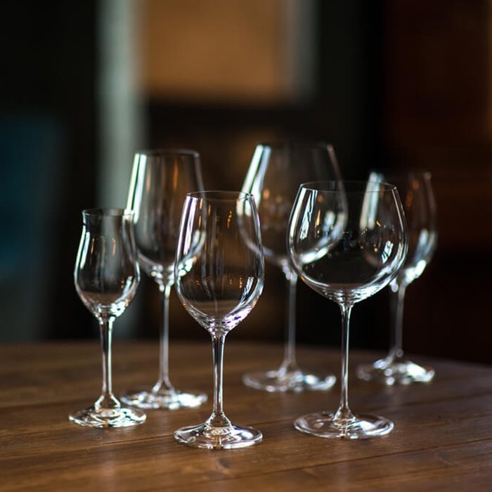 Different types of glasses for wine on wooden table. Still life concept.; Shutterstock ID 605362292