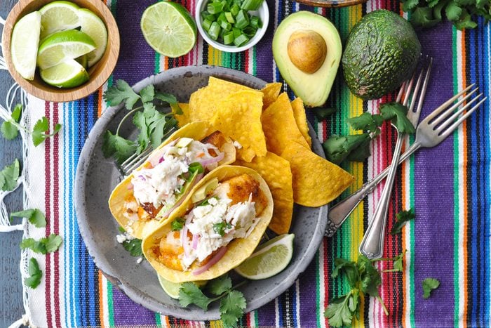 fish tacos on a festive decorated table with toppings